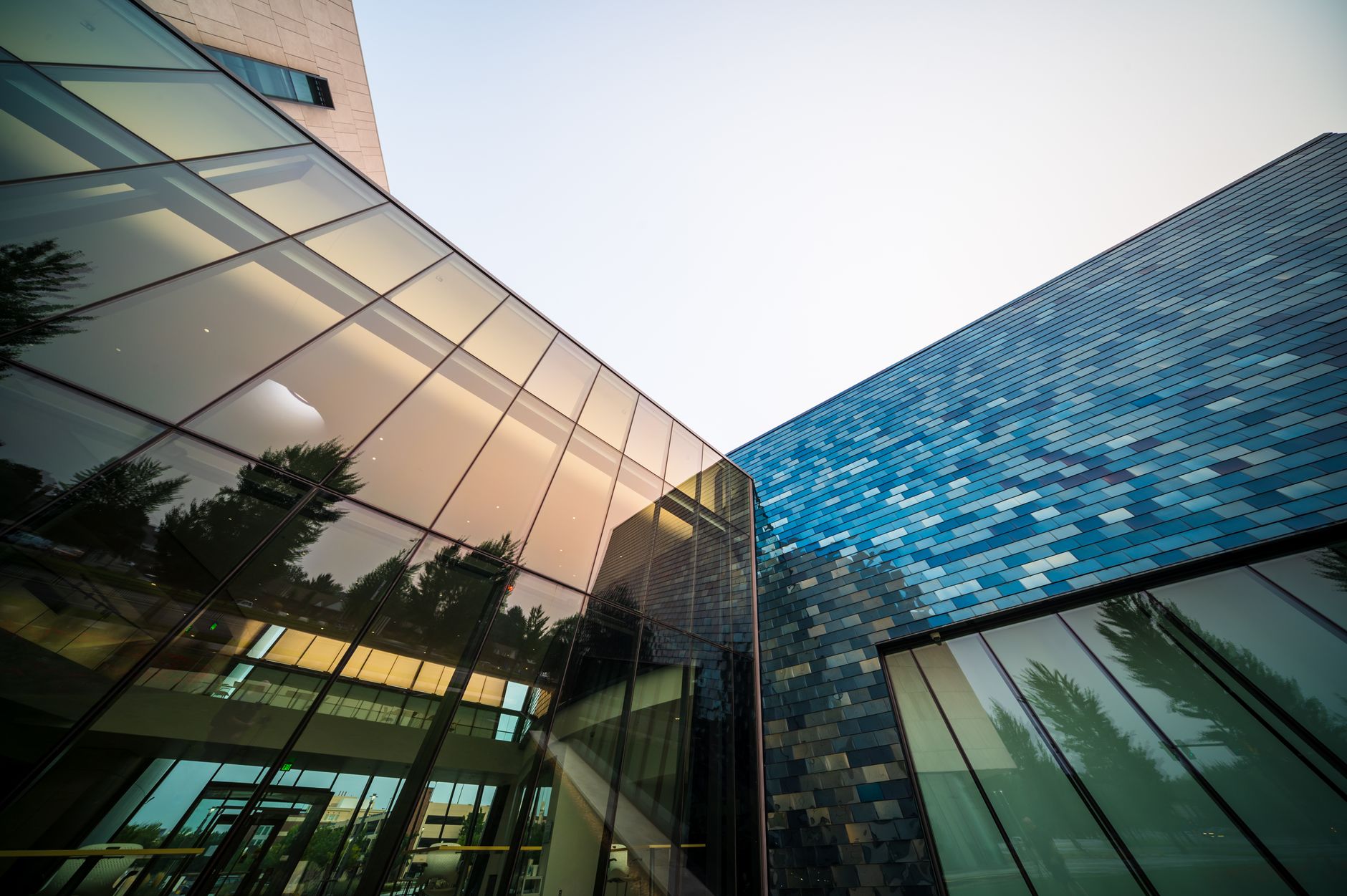 exterior of a modern Israeli technology campus at dusk, with glass-walled research buildings and outdoor pathways lit by low ambient lighting