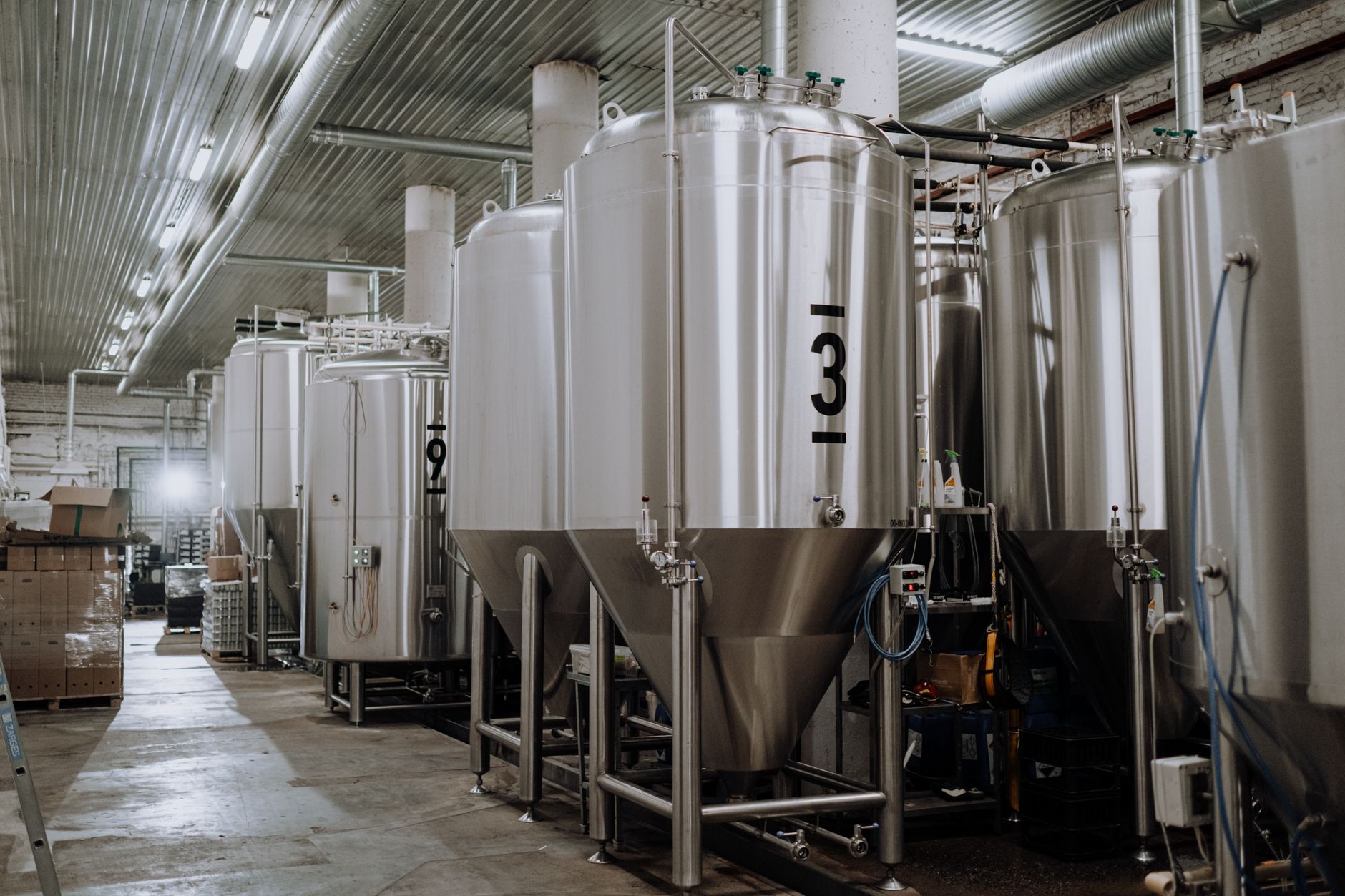 interior of a modern coffee processing facility showing large stainless steel decaffeination vessels along a production line, industrial overhead lighting