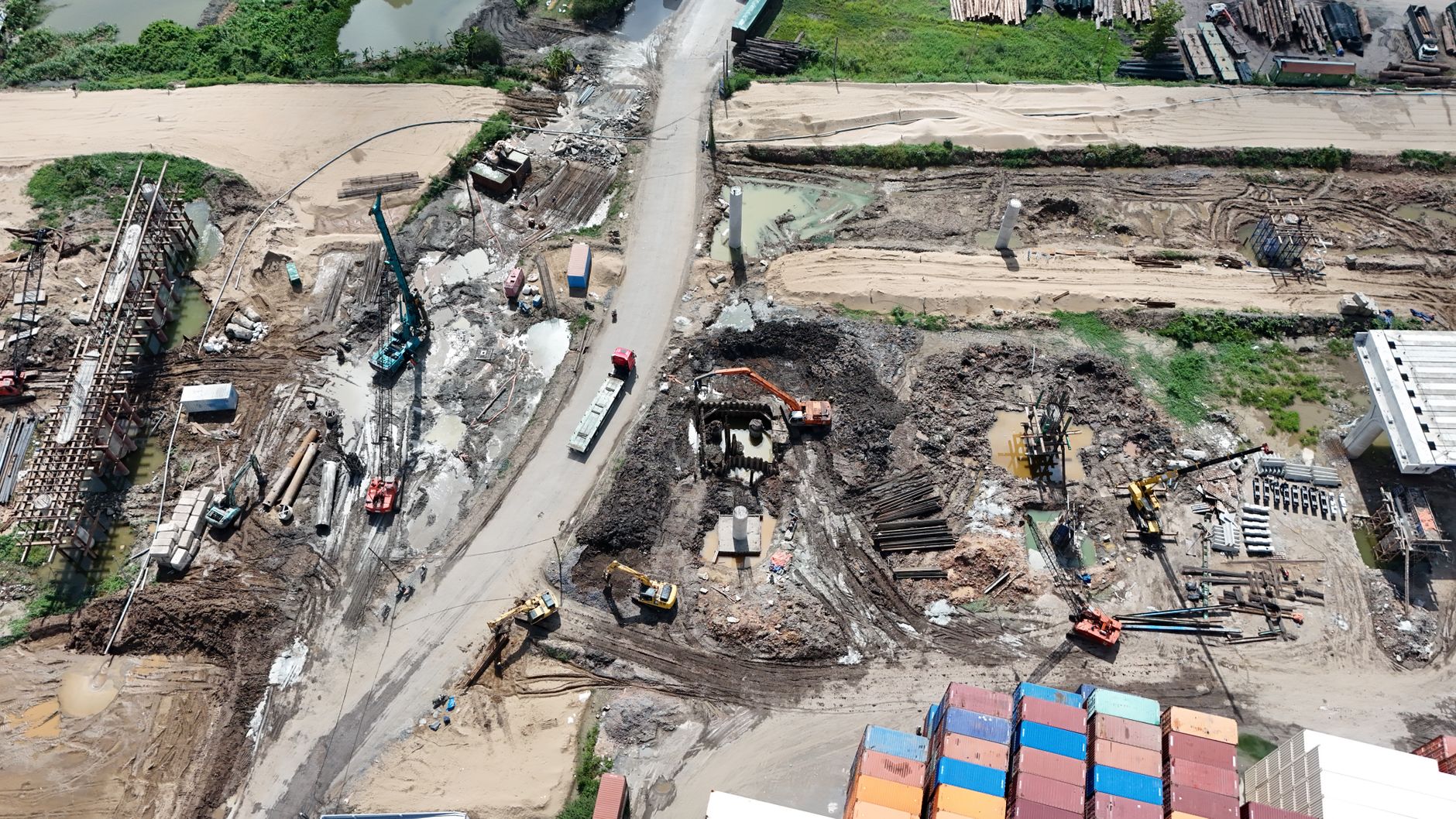 aerial view of a large-scale data centre campus under construction at the edge of a city, cranes and foundation works visible
