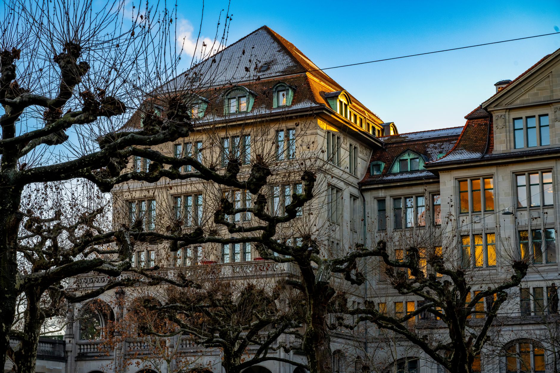 exterior of the Swiss National Bank building in Zurich on a clear afternoon, stone facade and entrance visible from across the street