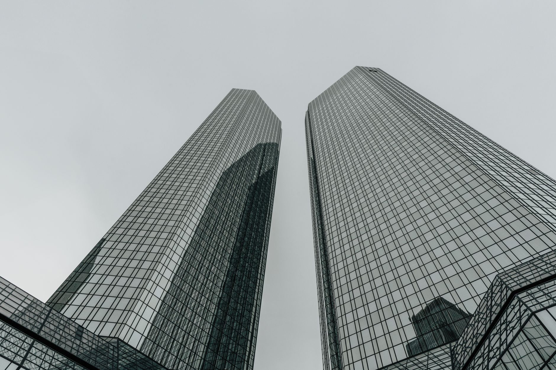 wide-angle exterior of the European Central Bank headquarters in Frankfurt at dusk, glass facade reflecting fading sky