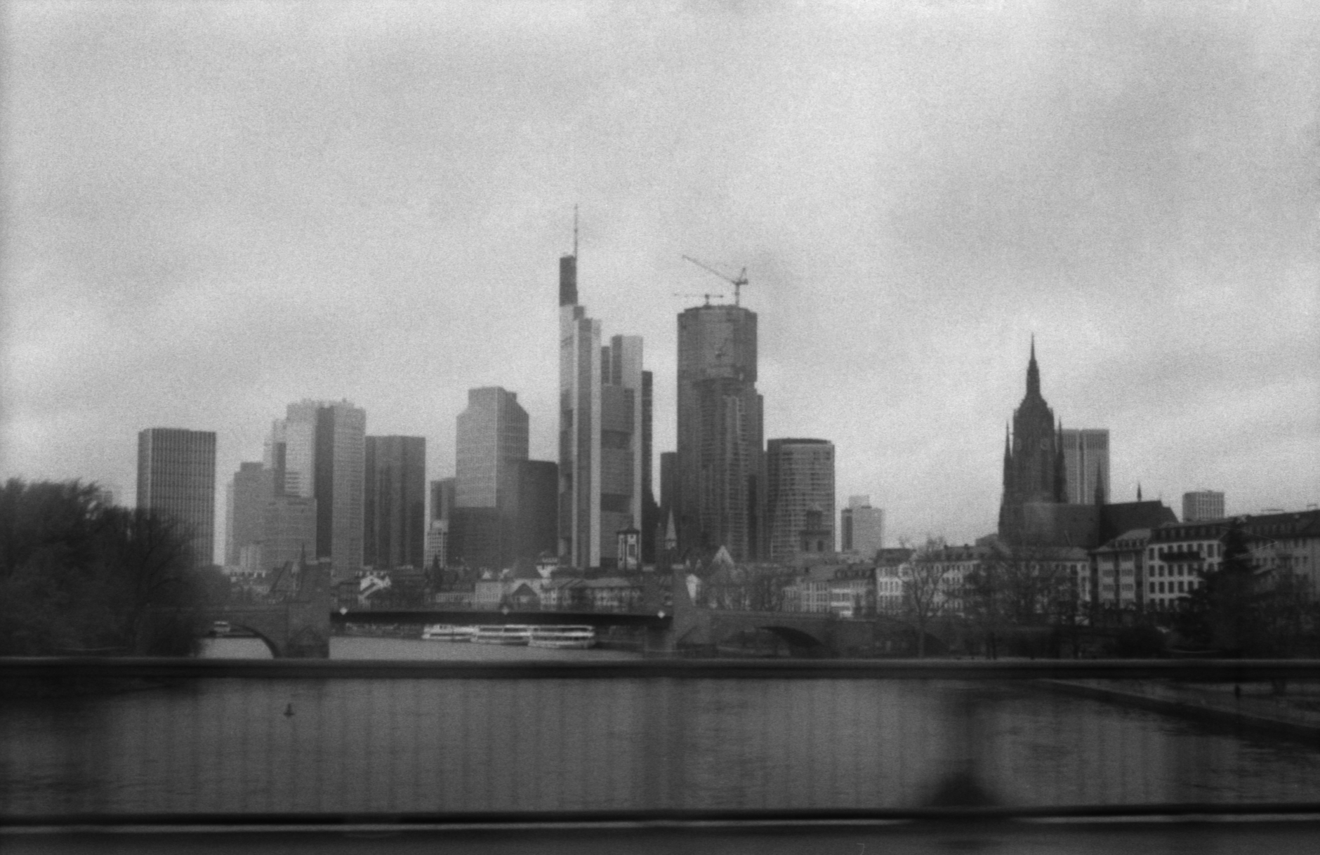 exterior of the European Central Bank headquarters in Frankfurt, Germany, with the euro sculpture visible in the foreground against an overcast sky