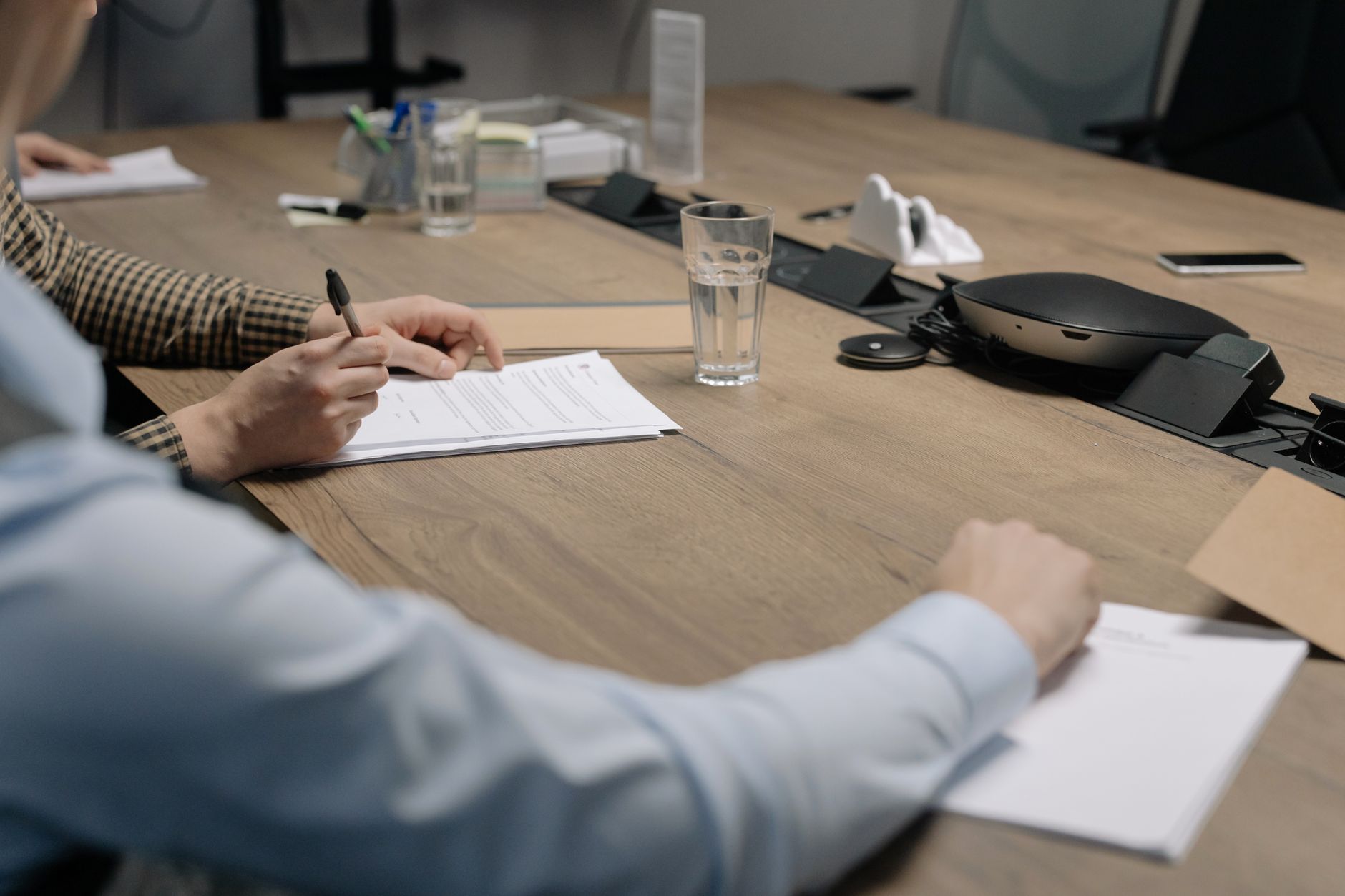 interior of a legal office with open estate planning documents spread across a wooden desk, a pen resting beside a trust agreement form, warm afternoon light through frosted windows