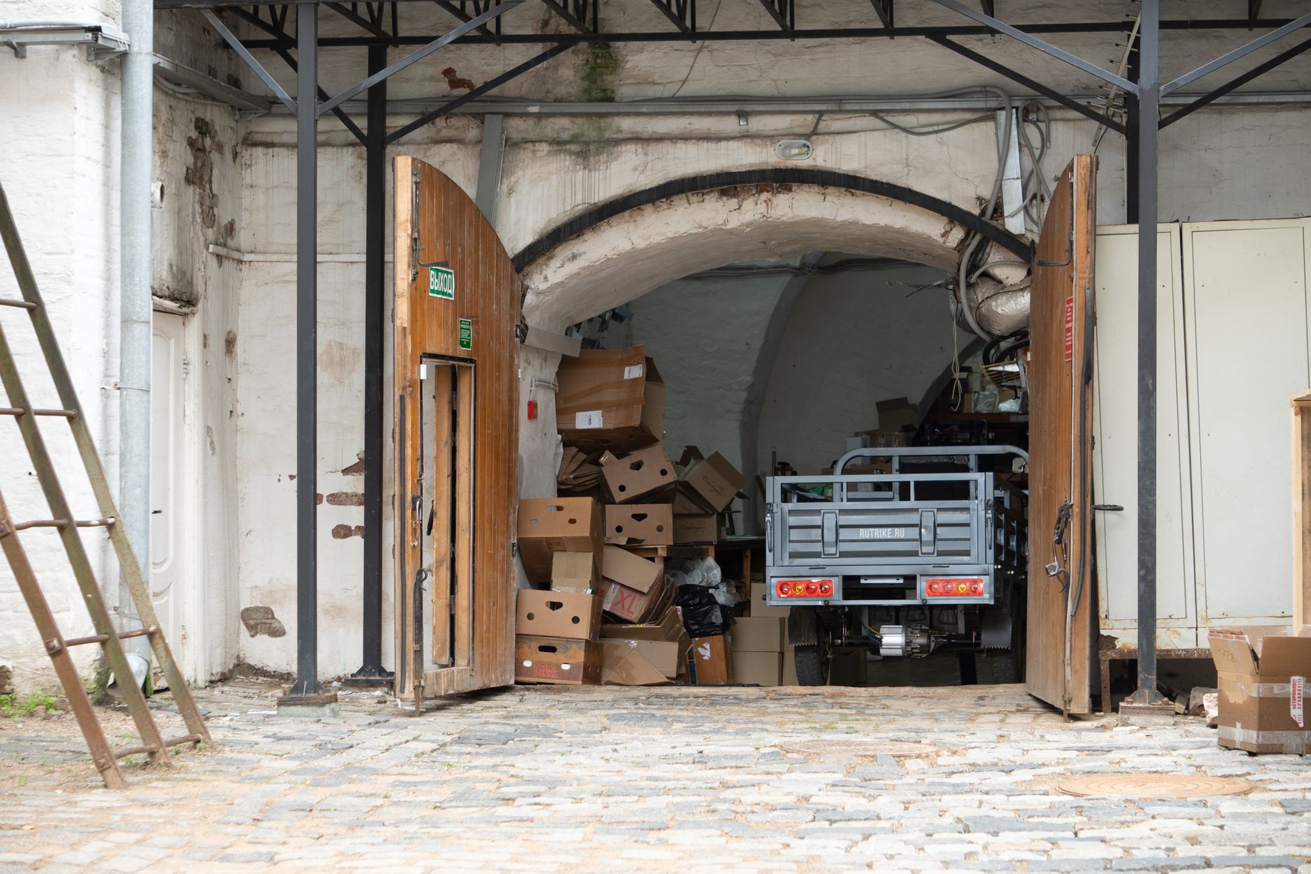 exterior of a mid-sized European municipality waste processing and packaging return facility with loading docks and collection bins visible