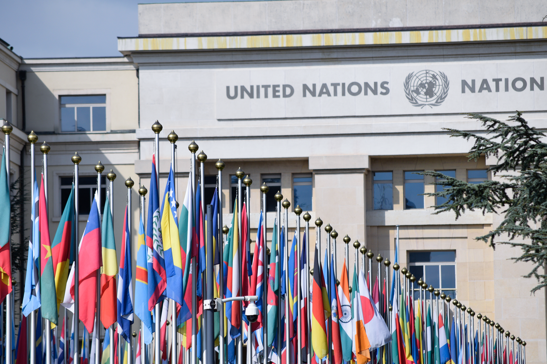 exterior of a large governmental conference centre with flags of European Union member states lining the entrance forecourt
