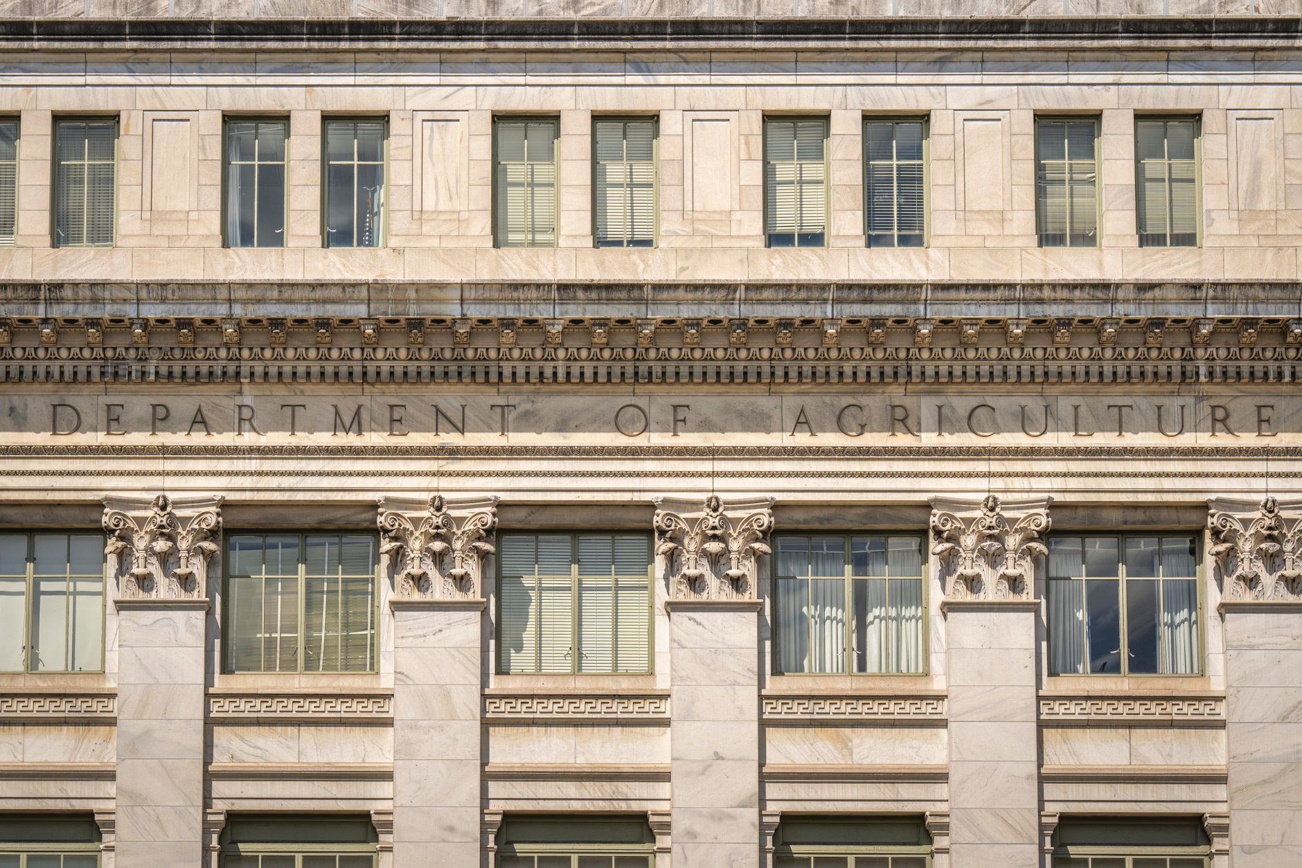 exterior of the Marriner S. Eccles Federal Reserve Board Building in Washington D.C. on an overcast autumn morning, wide shot showing the neoclassical stone facade and surrounding trees