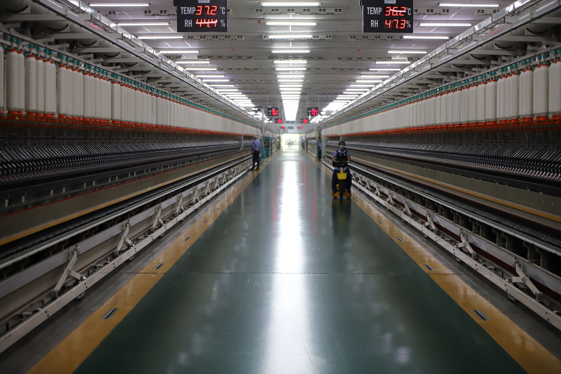 interior of a large modern manufacturing facility in India with rows of automated assembly equipment and industrial lighting overhead