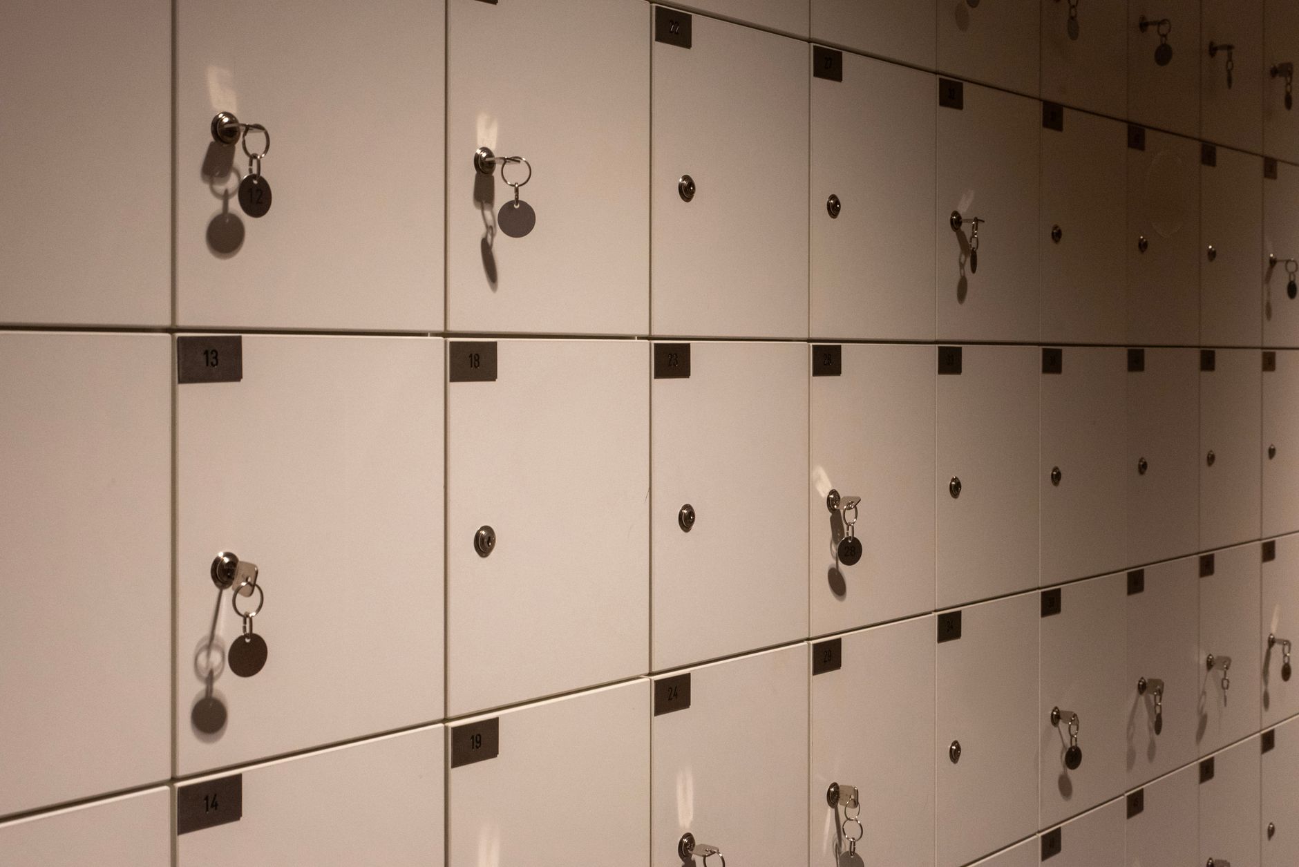 rows of gold bullion bars stacked in a secure vault facility, lit by overhead industrial lighting