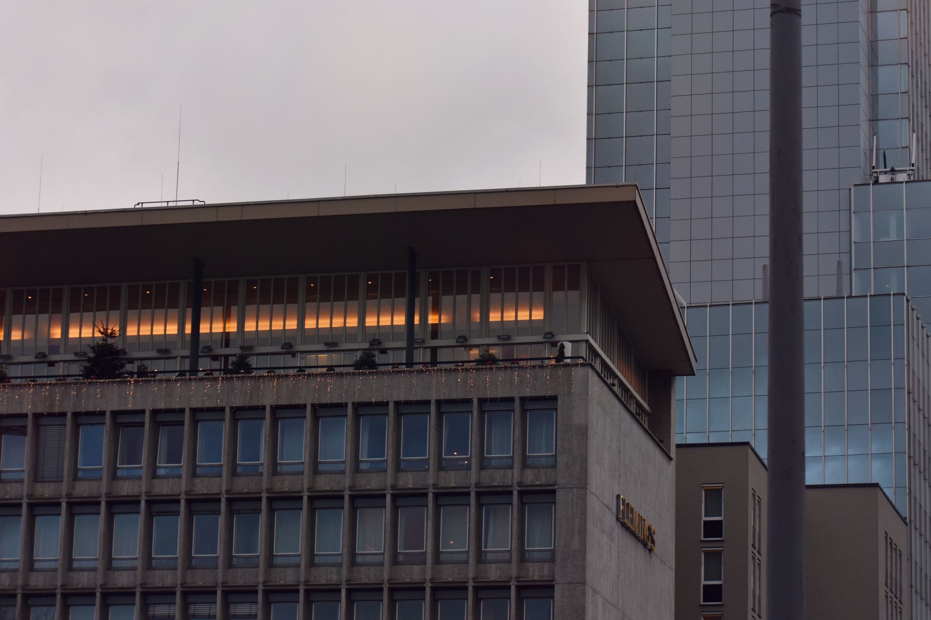 exterior of a commodities exchange building at dusk, with the street below reflecting overhead neon and glass facades