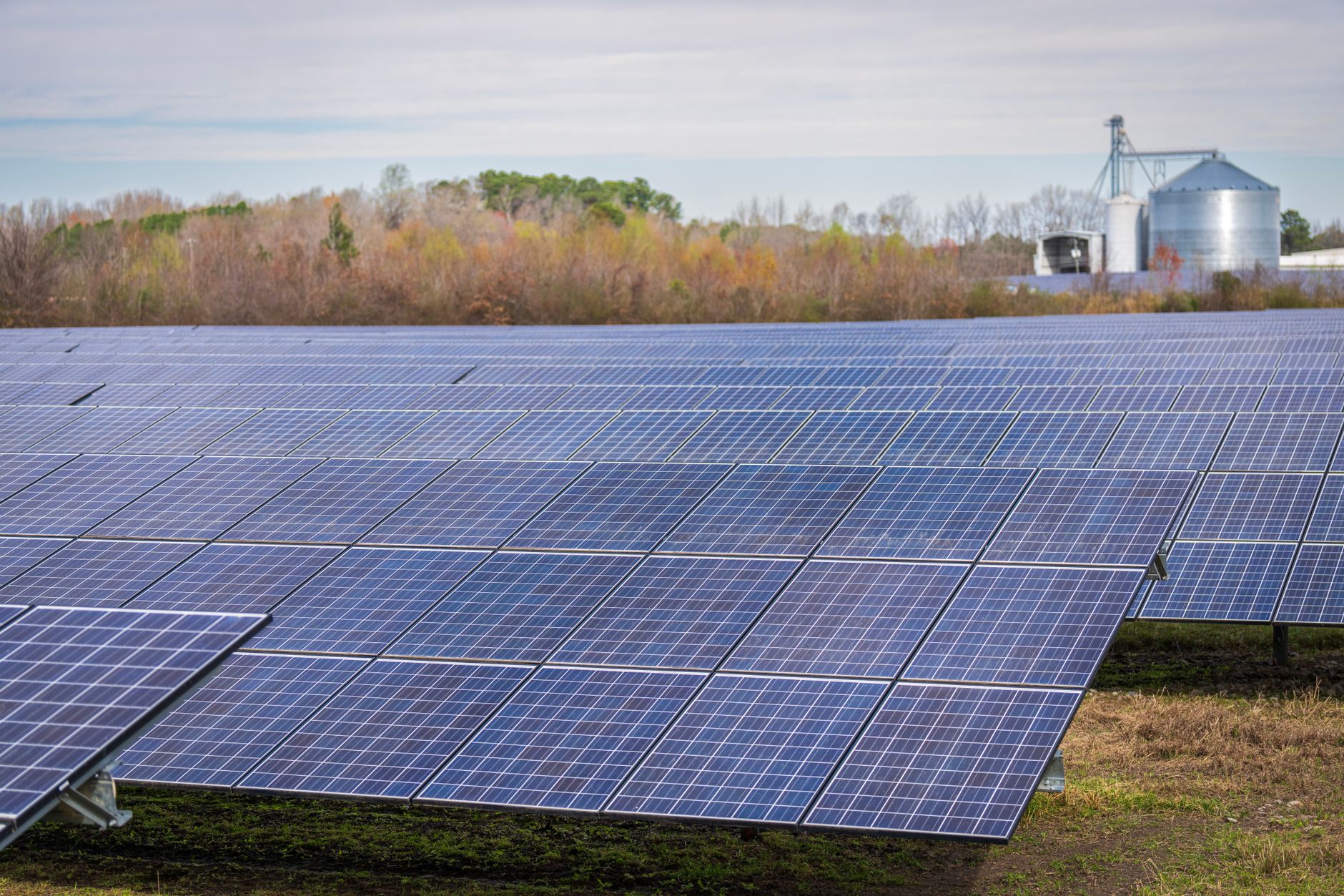 exterior of a solar panel manufacturing facility with rows of photovoltaic modules arranged across an open industrial yard