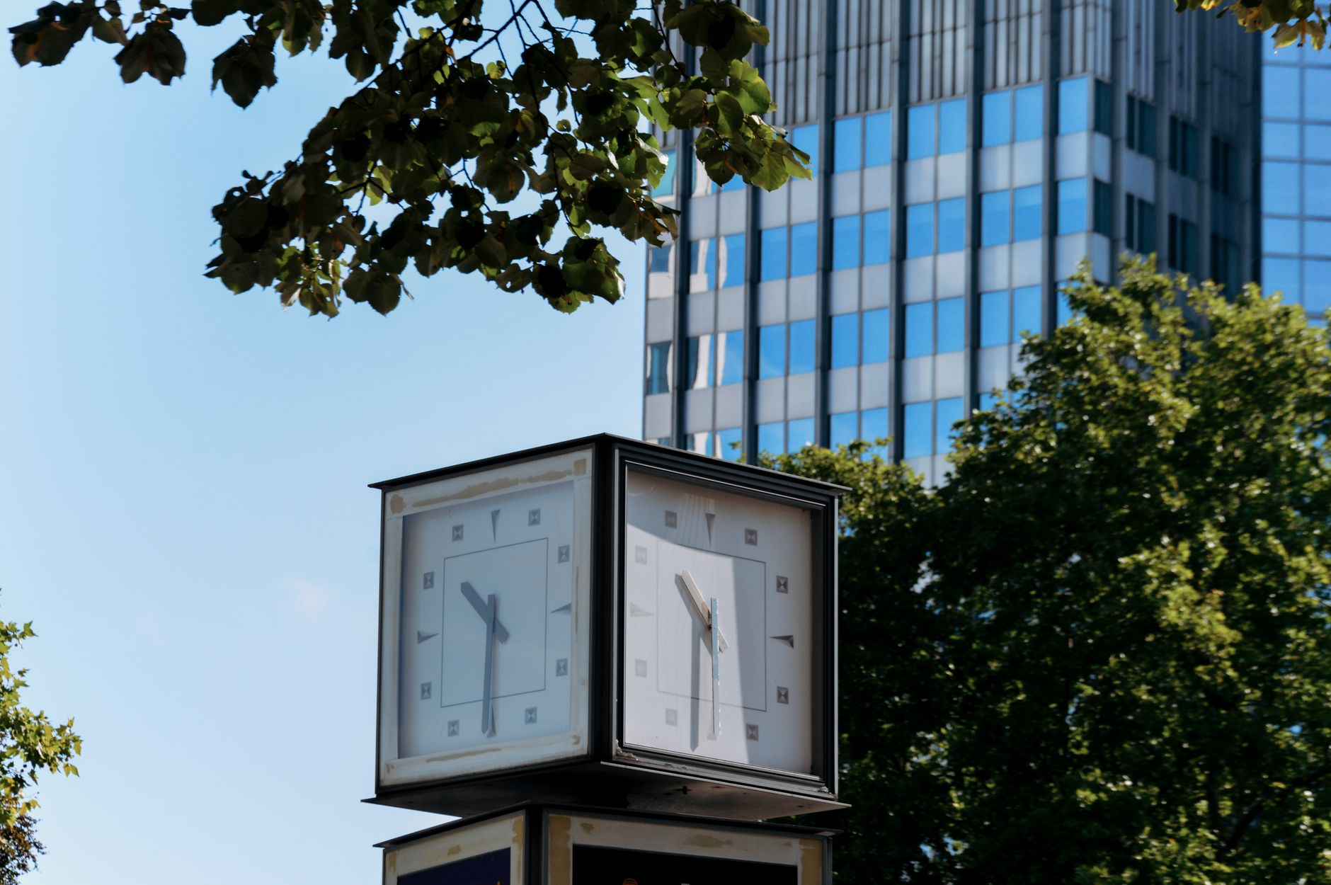 exterior of a modern Nasdaq MarketSite building in Times Square, lit signage visible against a clear morning sky