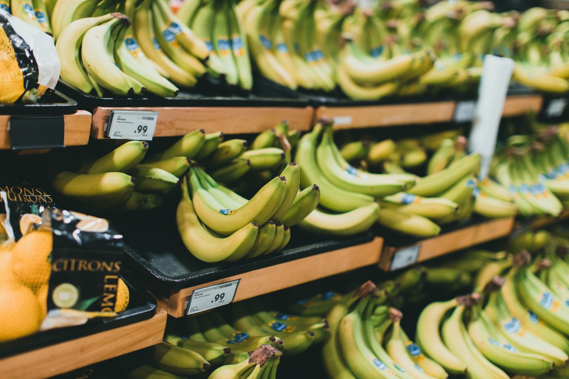 a nearly empty supermarket aisle with sparsely stocked shelves and handwritten price tags on remaining items