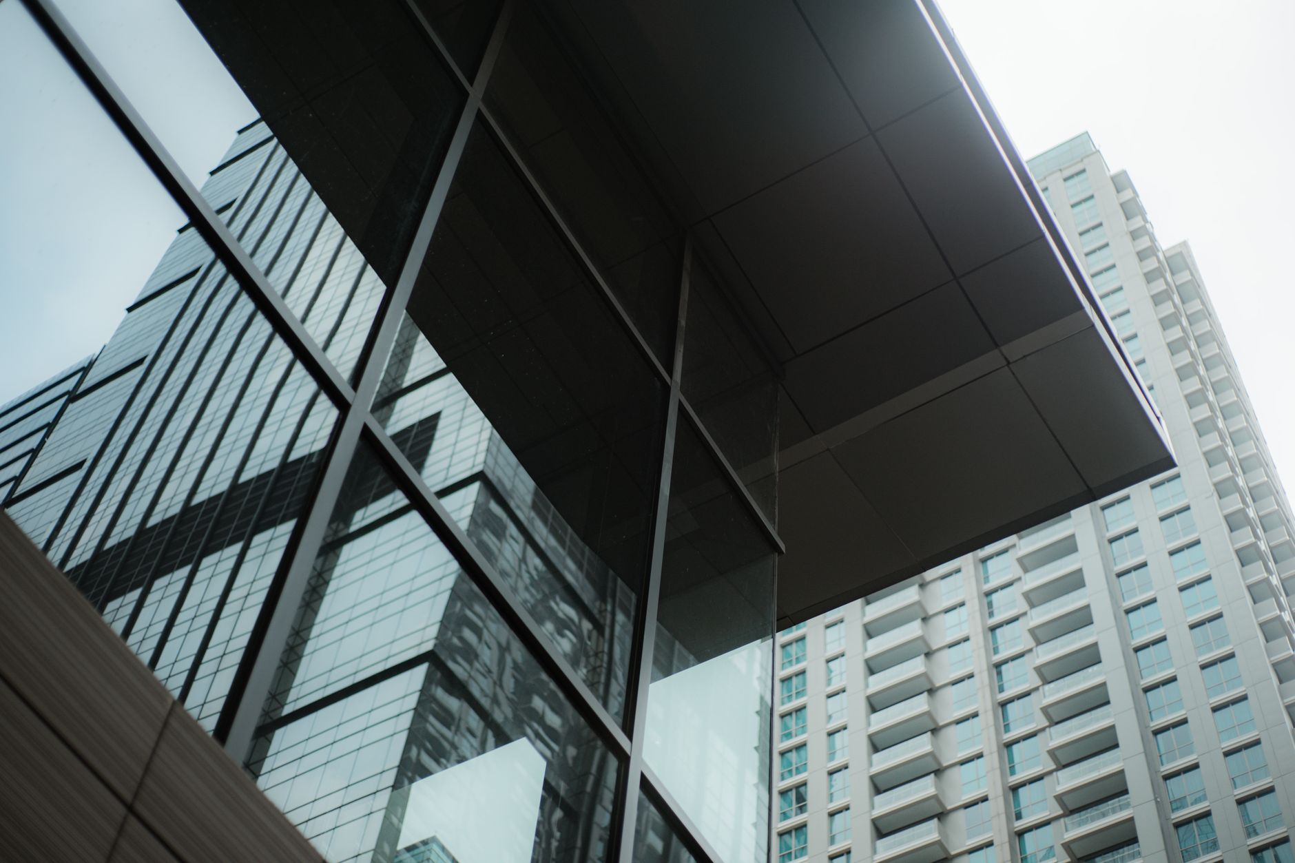 exterior of a modern glass-fronted technology office building in Tel Aviv's central business district at midday, with urban street and light rail infrastructure visible in the background