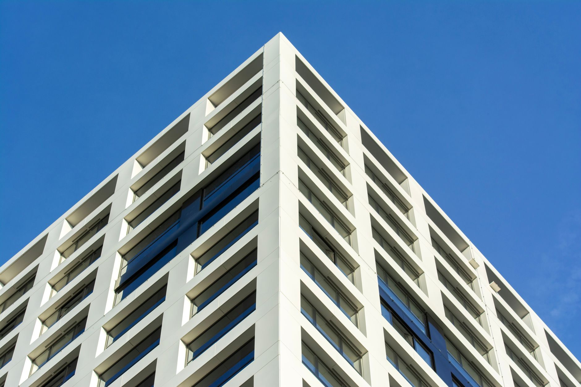 exterior of a modern Israeli bank branch building on a city street corner at midday, with ATM alcoves visible along the facade