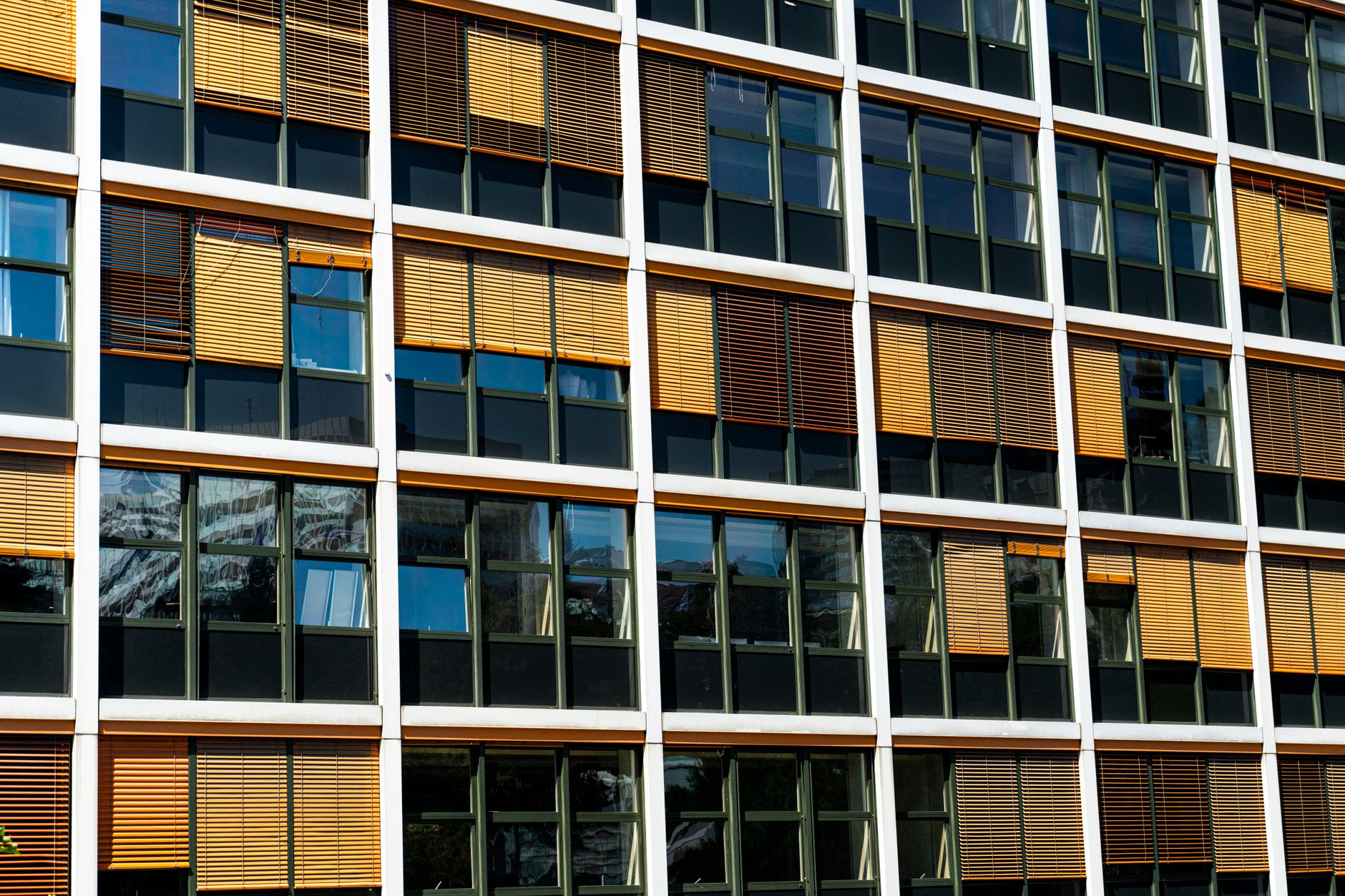 exterior of a modern government ministry building in Jerusalem, glass facade reflecting afternoon sunlight, wide street-level view
