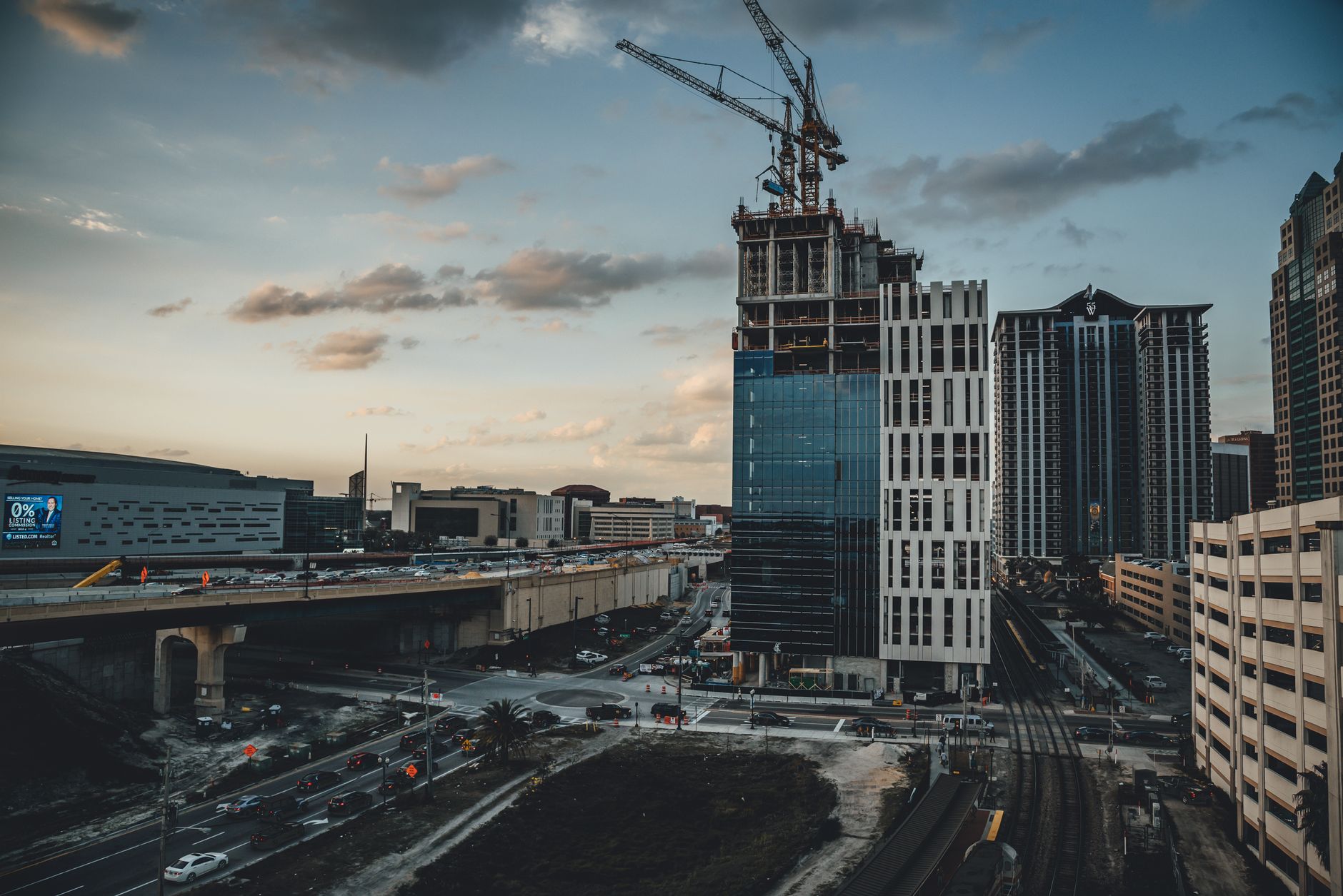 aerial view of the Tel Aviv skyline at dusk with office towers and construction cranes visible along the coastline