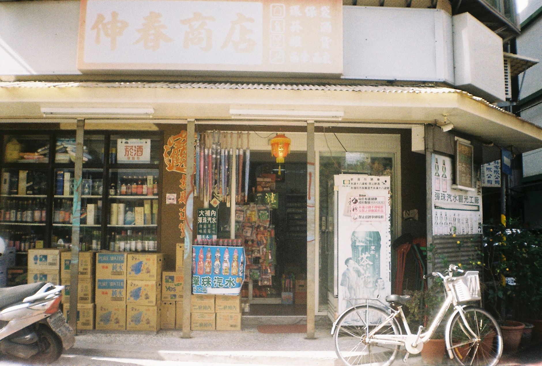 exterior of a large Ito-Yokado retail store building at street level in an urban Japanese setting, with parked bicycles along the pavement and overhead signage visible