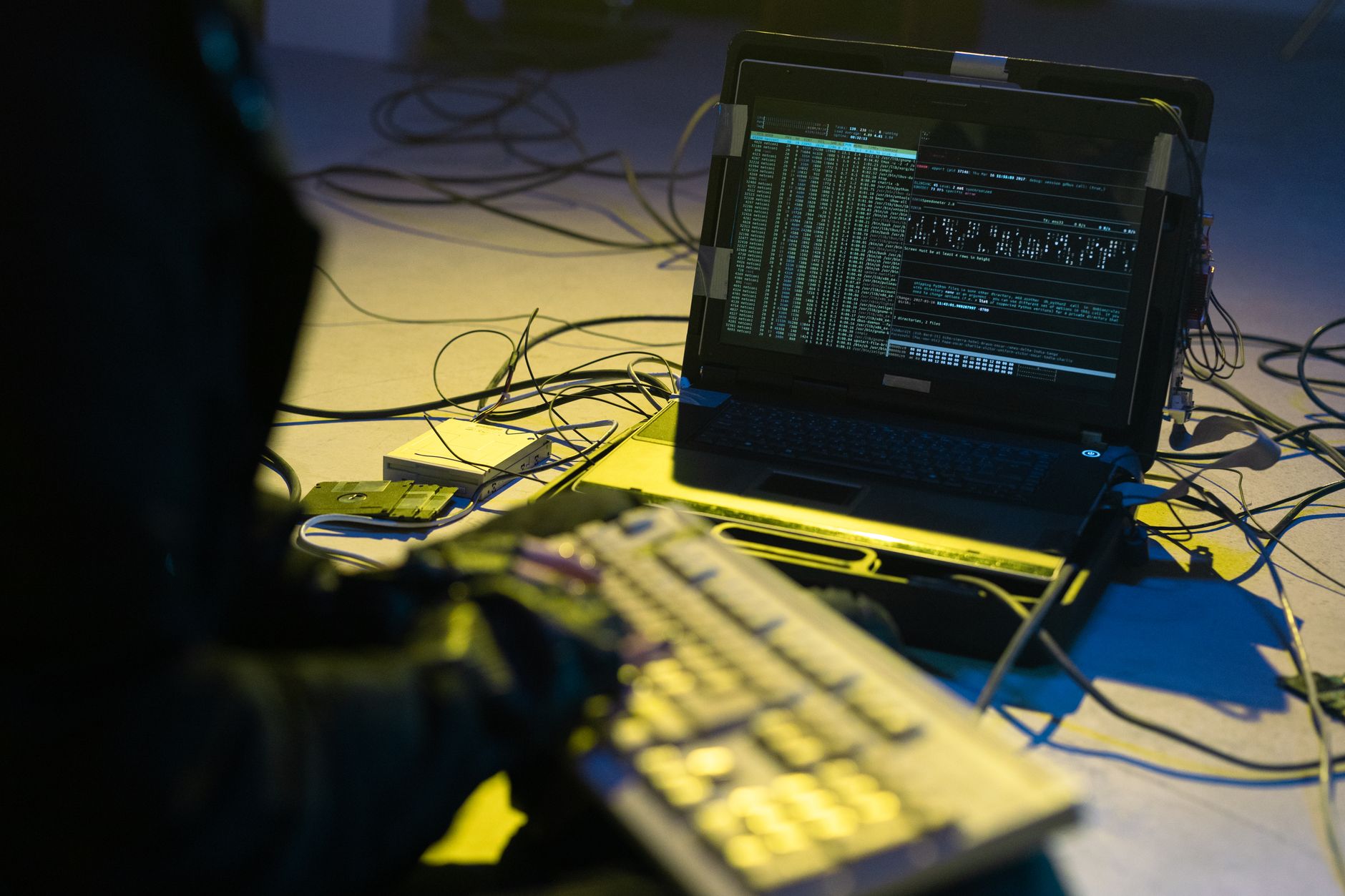 close-up of a laptop screen displaying network activity logs and access permissions in a corporate cybersecurity dashboard, keyboard partially visible in the foreground