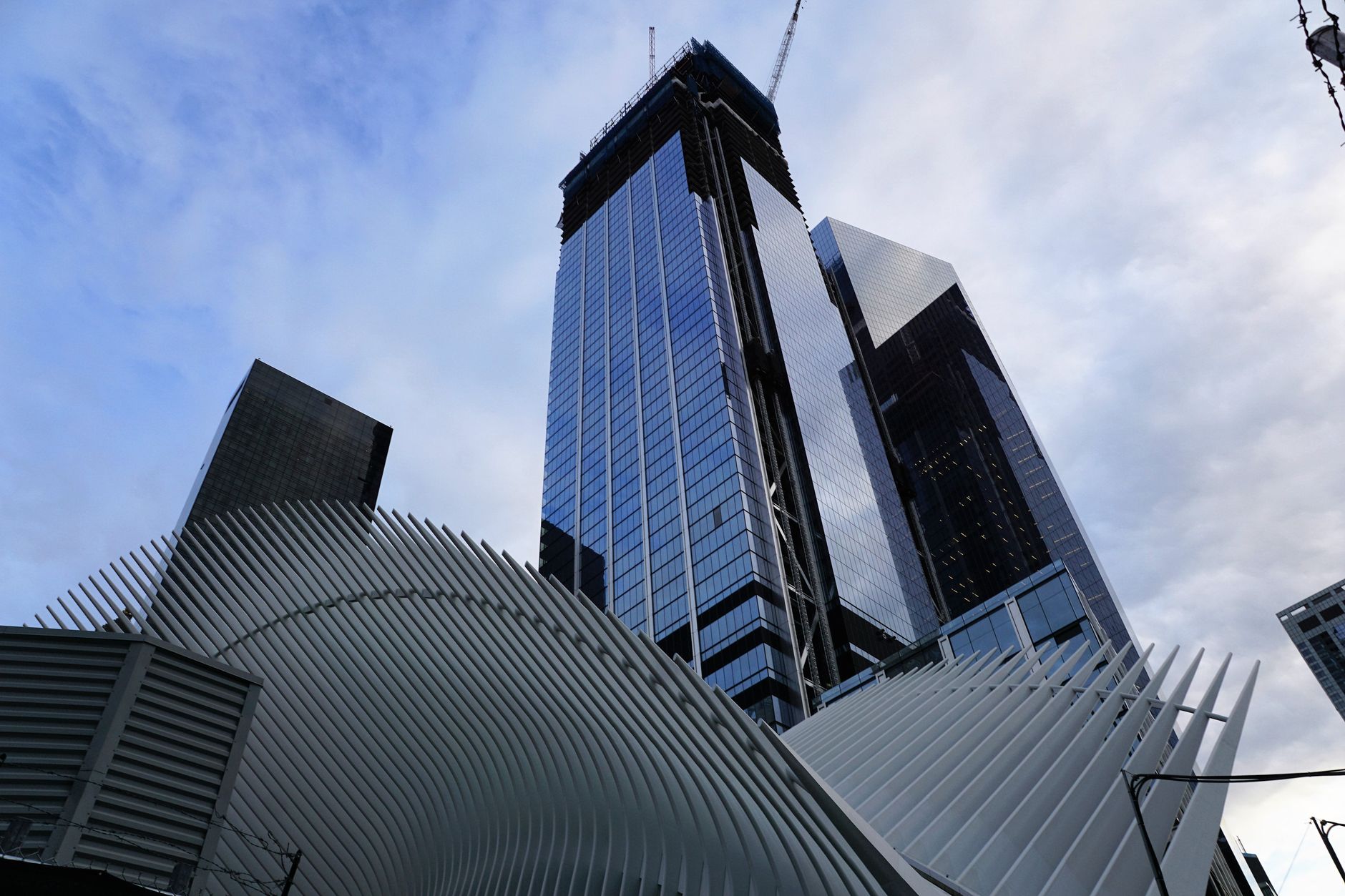 exterior of a modern glass-and-steel corporate technology campus in New York City, empty plaza in foreground with architectural lighting at dusk