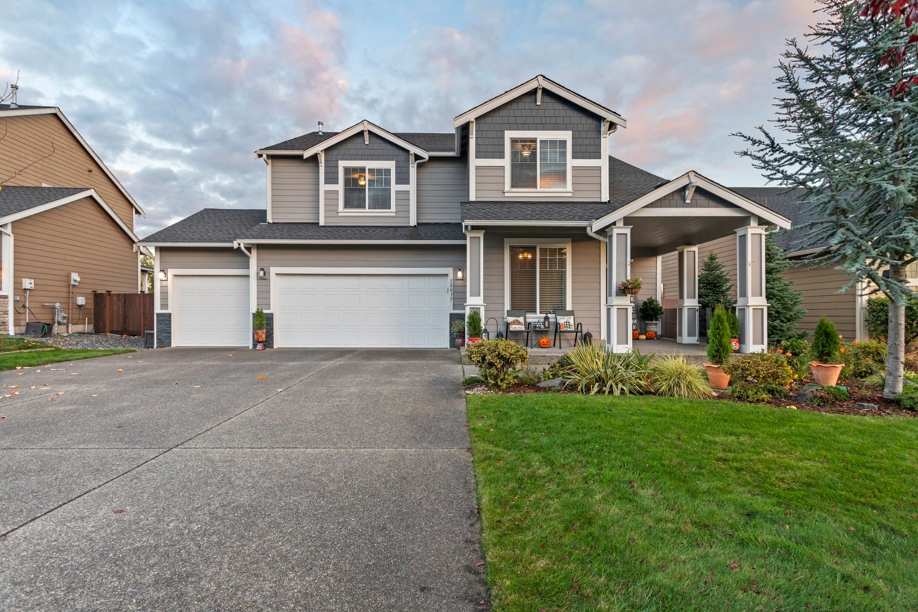 exterior view of a row of suburban homes with for-sale signs in front yards on a quiet residential street, overcast morning light