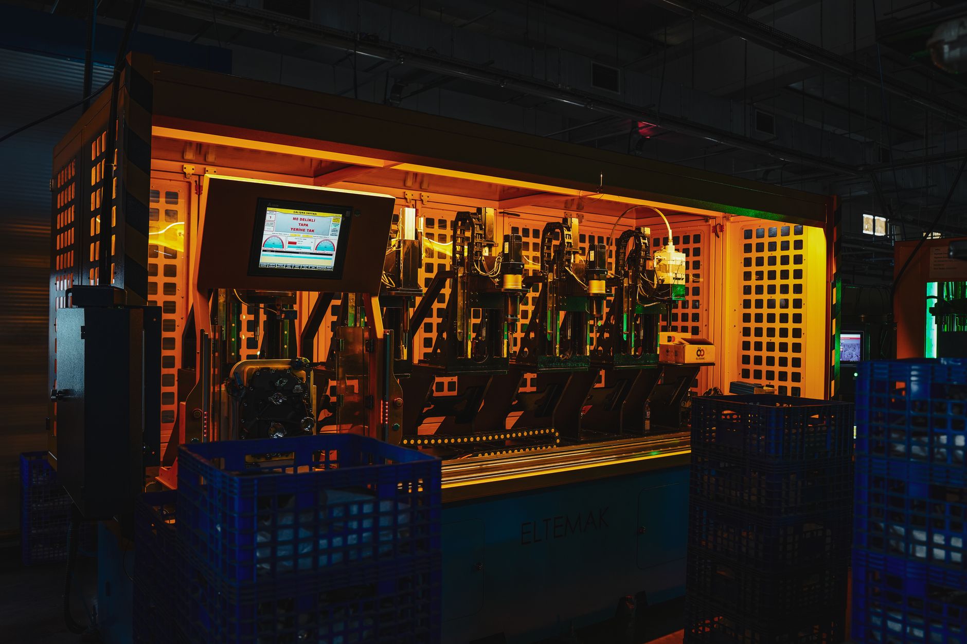 close-up of industrial robotic arms on an automated assembly line inside a modern Indian factory, with circuit board components on the production surface