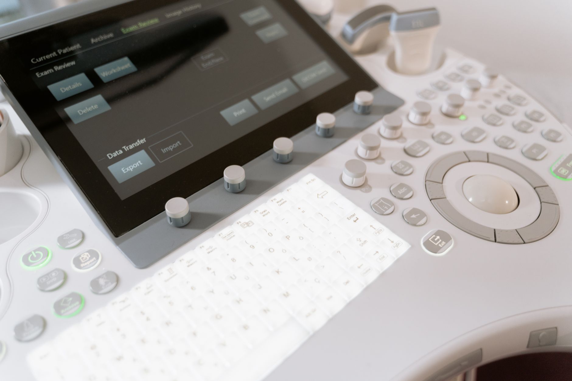 close-up of a medical technology demonstration station showing a touchscreen interface displaying patient data charts and diagnostic imaging scans on a standing exhibit table