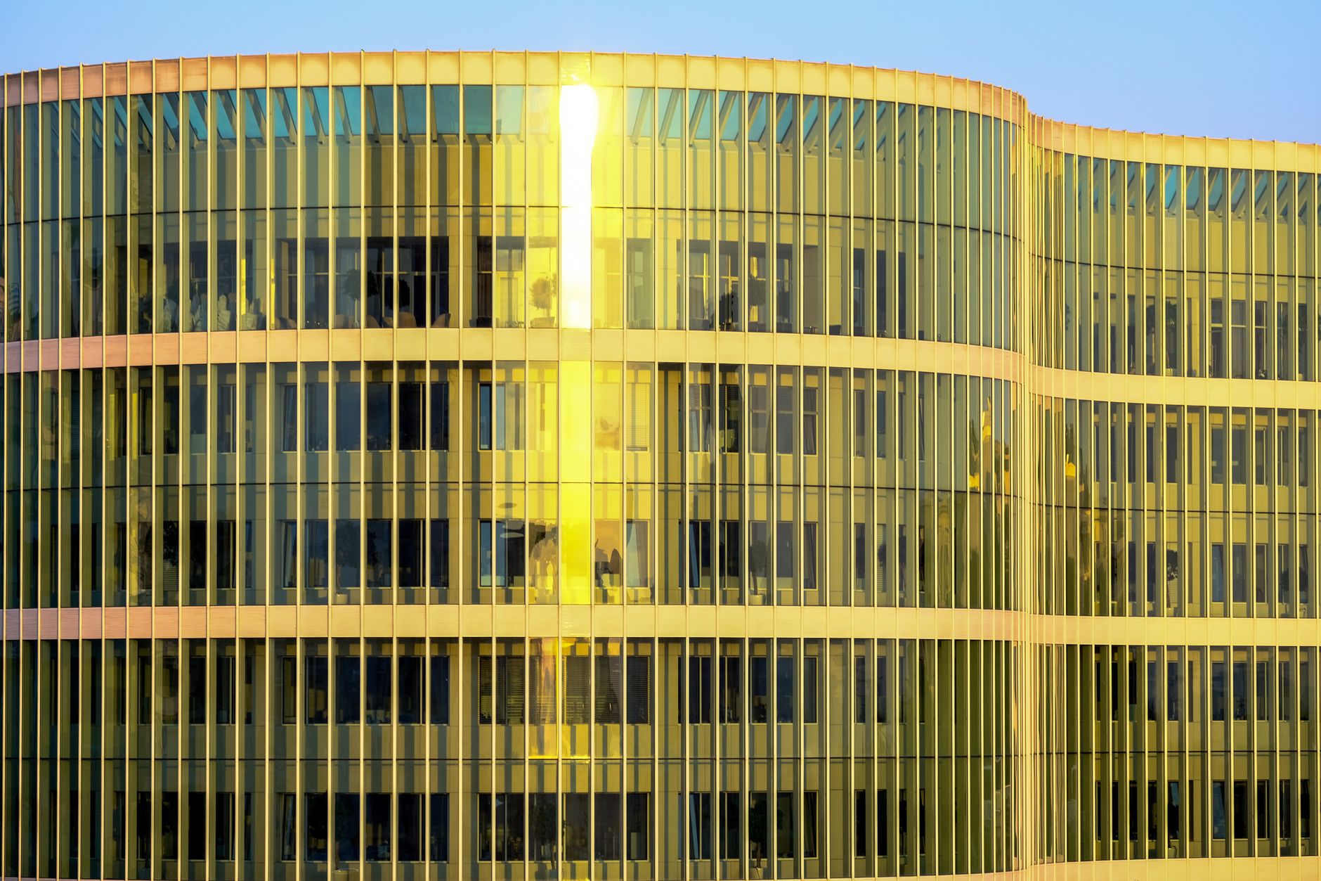 exterior of a modern Tel Aviv office building housing a venture capital firm, glass facade reflecting the midday sun with the city skyline visible in the background