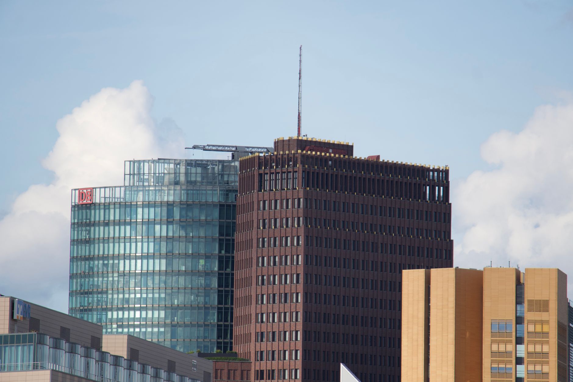 exterior of a large modern stock exchange building at midday, with glass facades reflecting city skyline