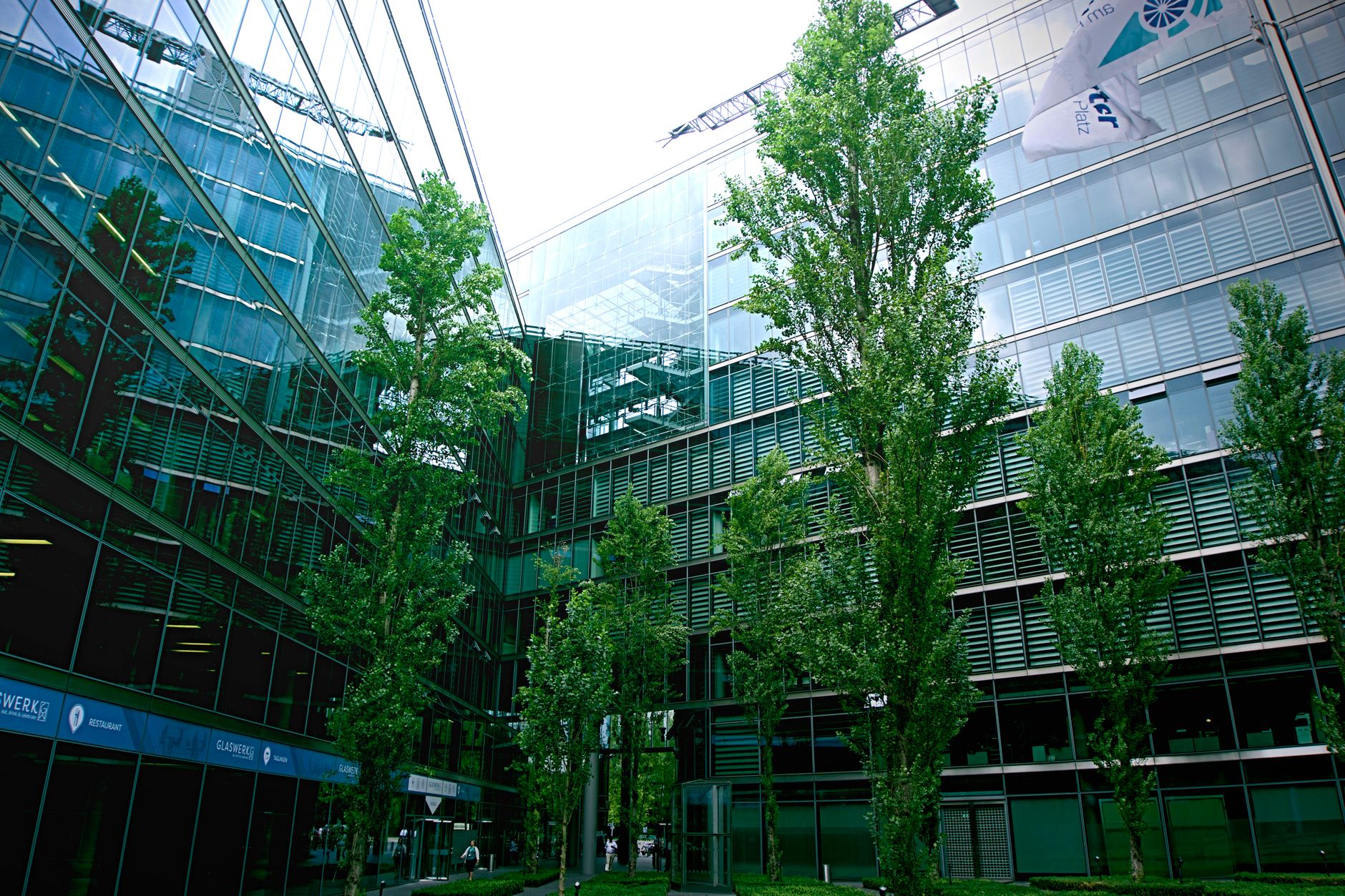 exterior of a large corporate campus with glass office buildings and a partially empty car park at midday