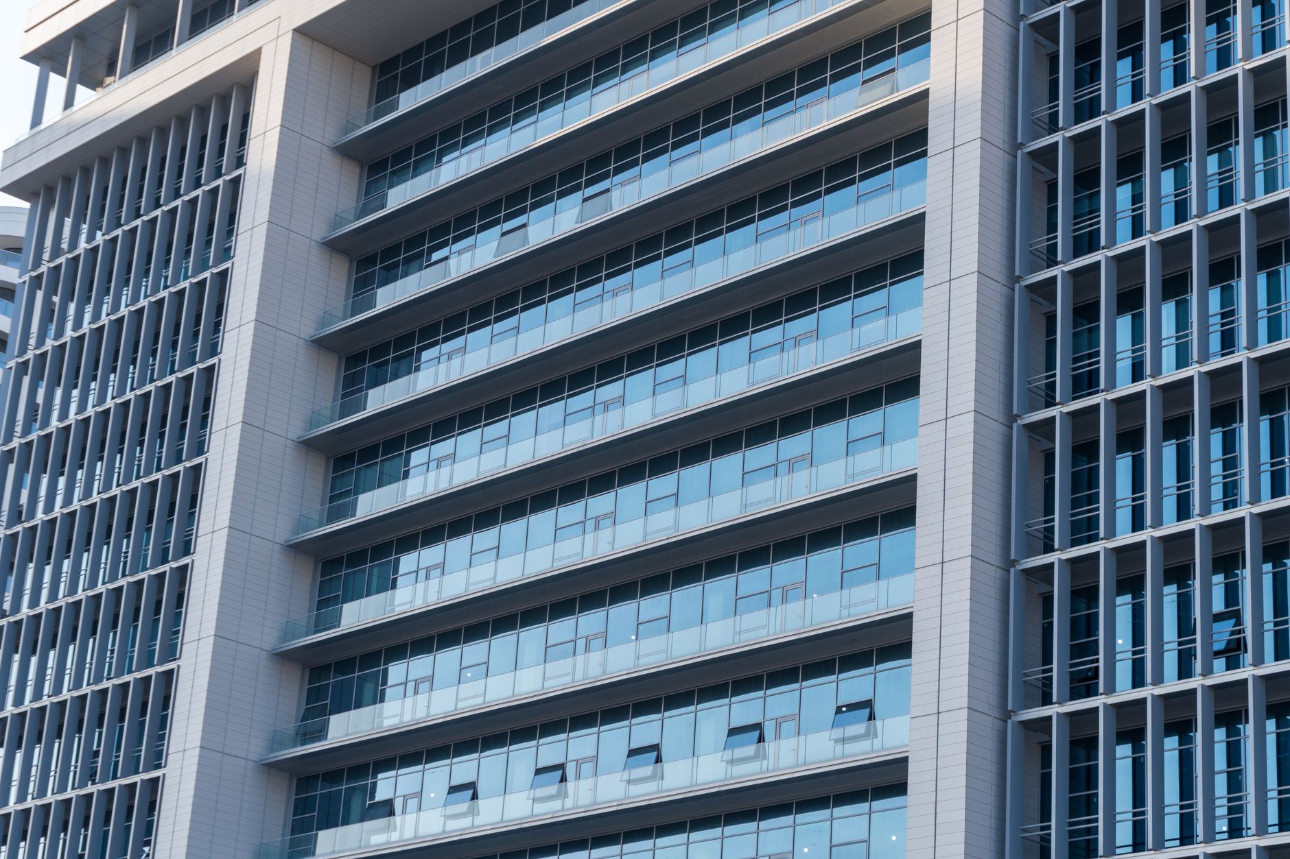 exterior of a modern Tel Aviv office building housing a technology firm, glass facade reflecting afternoon sunlight, street-level view with parked vehicles visible