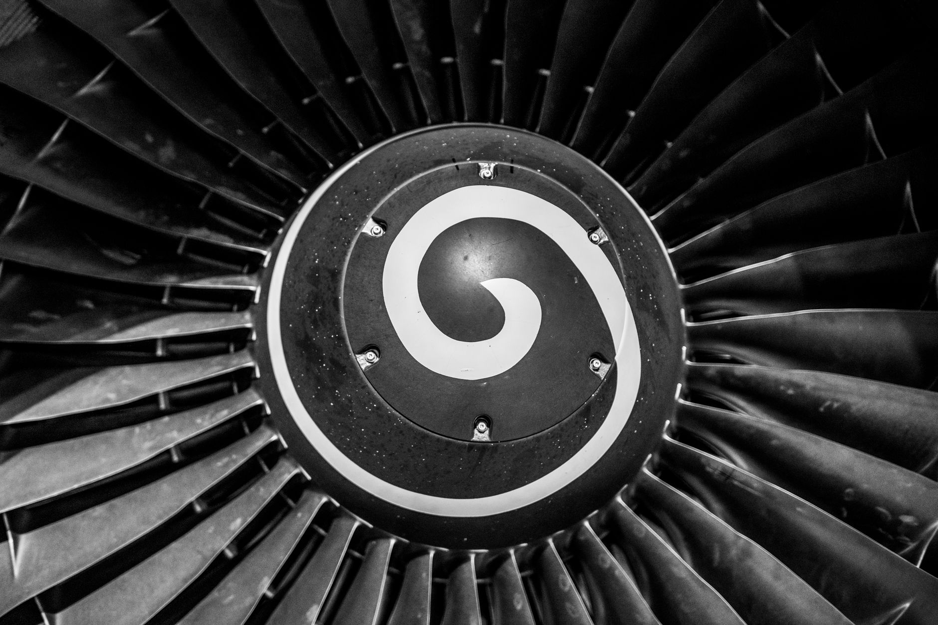 rows of aviation turbine components lined up inside a large industrial warehouse under bright overhead lighting