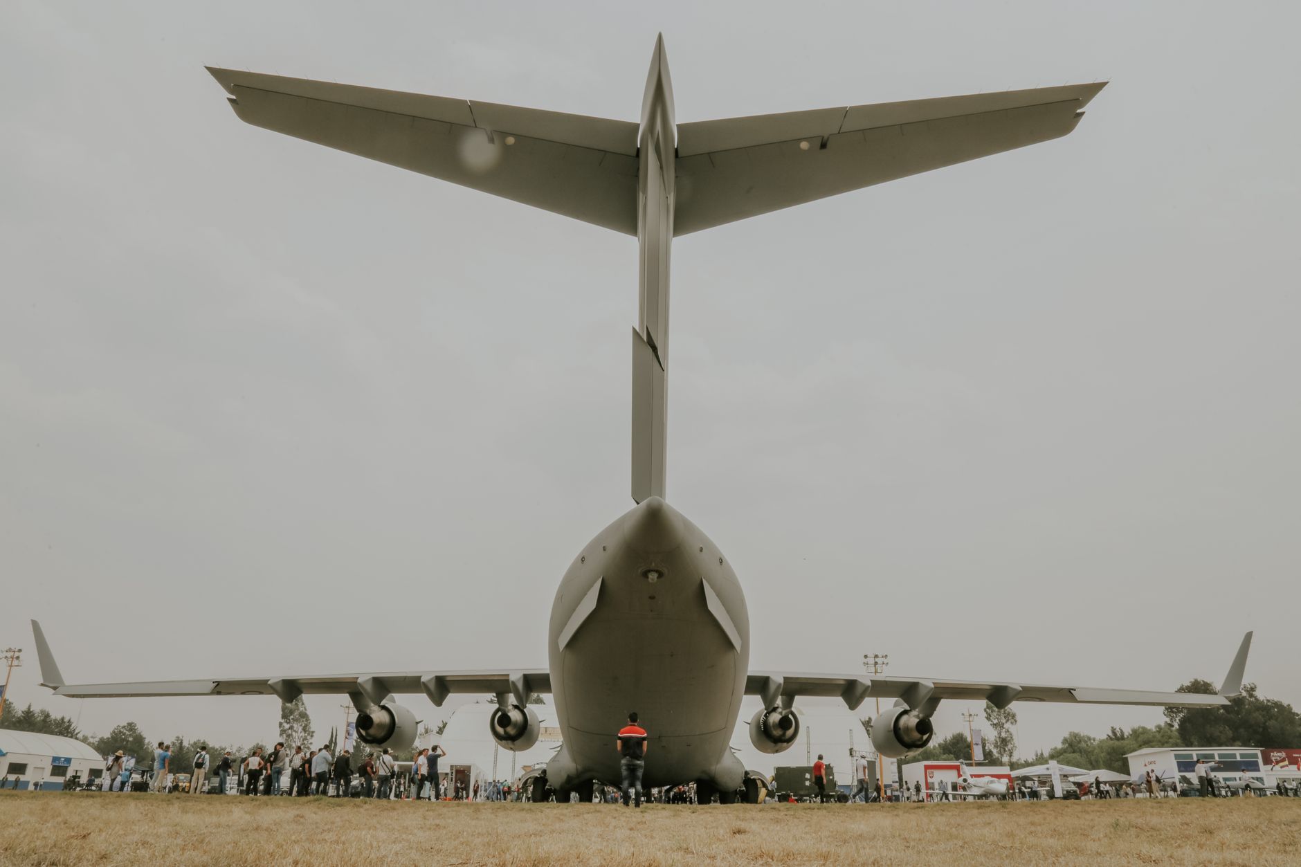 aerial view of a large military airfield with rows of cargo aircraft parked on tarmac at dusk