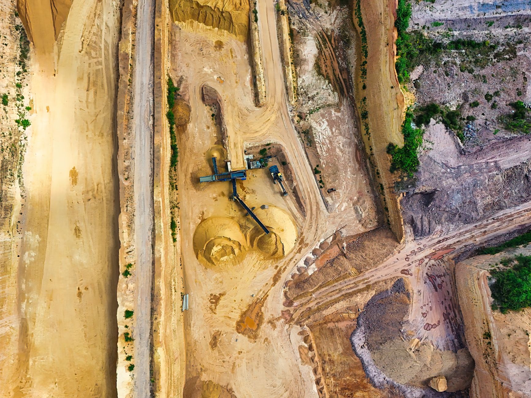 aerial view of heavy crude oil extraction infrastructure in a remote delta landscape, with pipelines cutting through dense tropical vegetation
