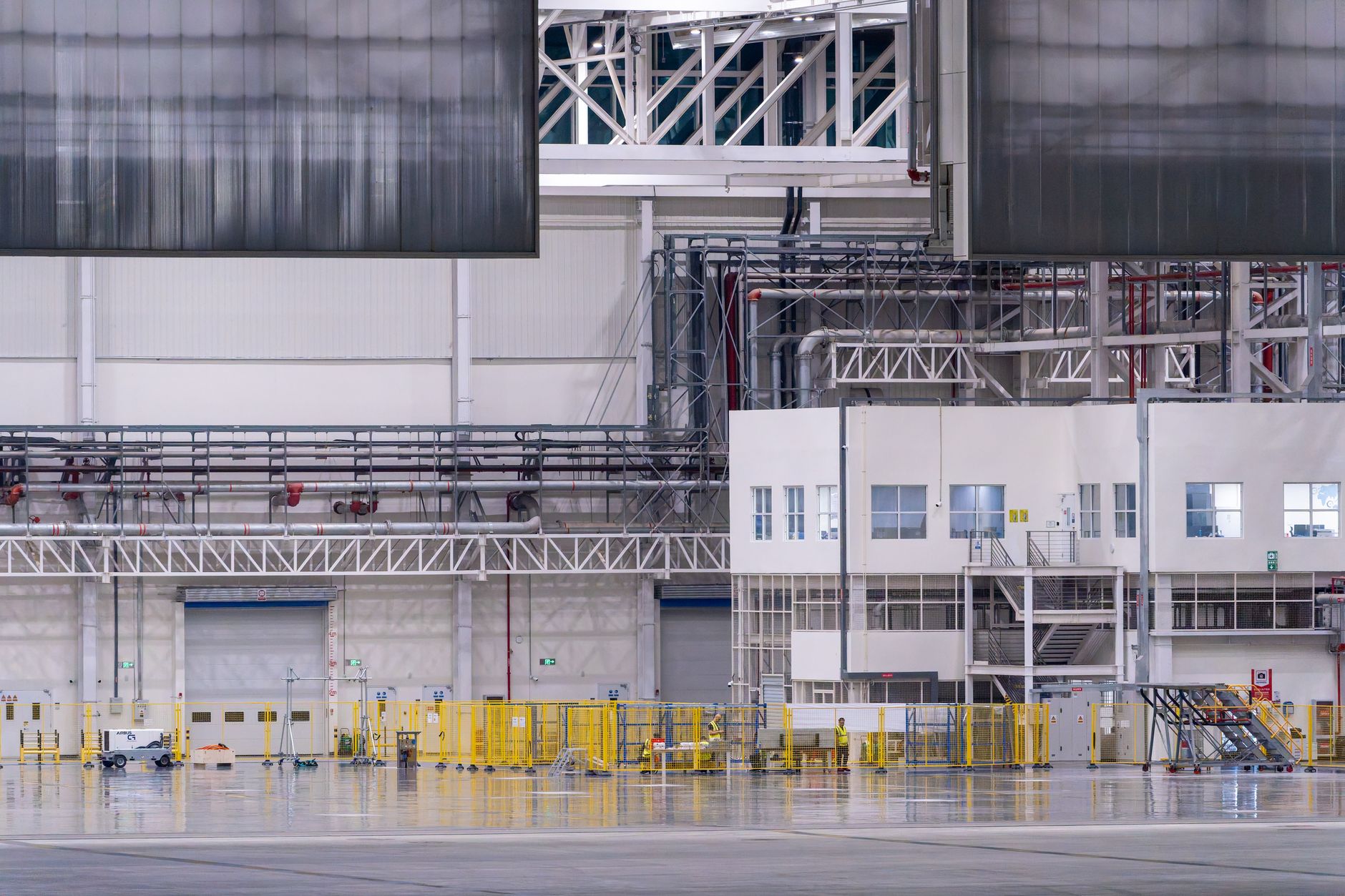 exterior of a modern Volvo Cars manufacturing facility with assembly lines visible through wide industrial windows at dusk