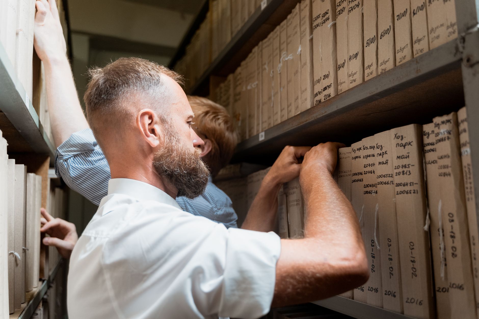 a row of filing cabinets and an open vault door inside a financial institution's records storage room