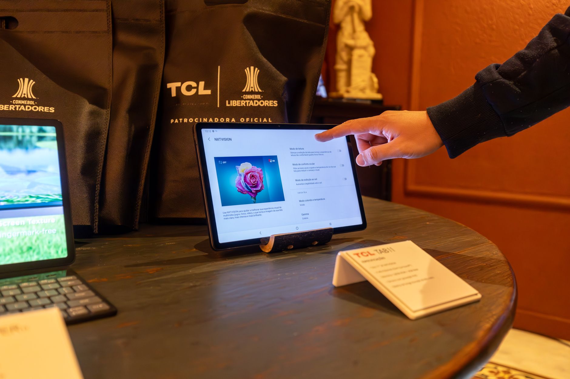 close-up of a tablet display showing an AI-powered product recommendation interface with multiple item cards and price comparisons, resting on a wooden desk