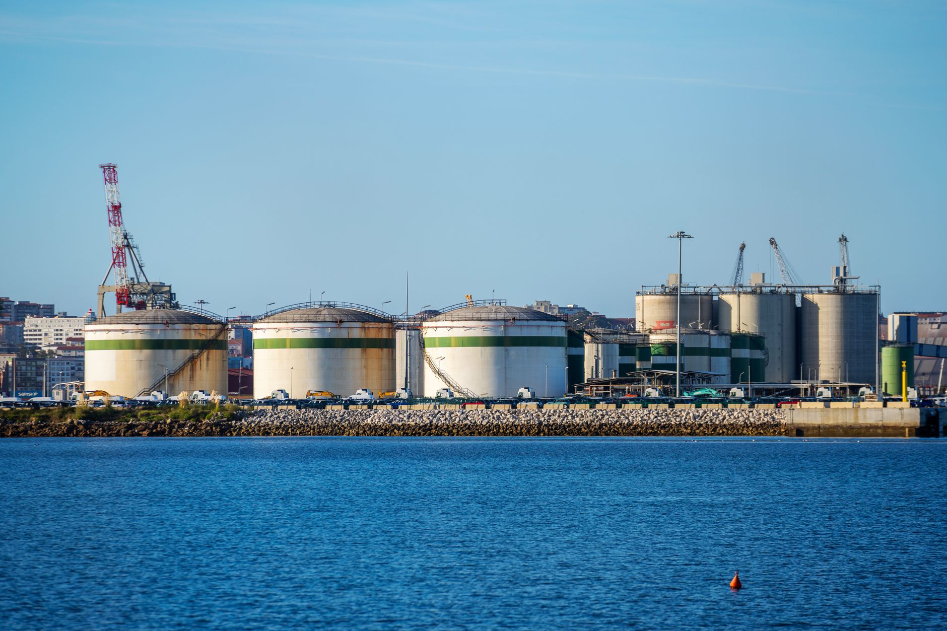 exterior view of a large telecommunications equipment manufacturing facility at dusk, with loading bays and industrial cranes in the background